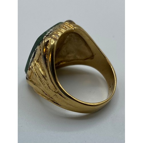 48 - An unmarked yellow metal ring set with rectangular nephrite plaque, 9.6 g, size V