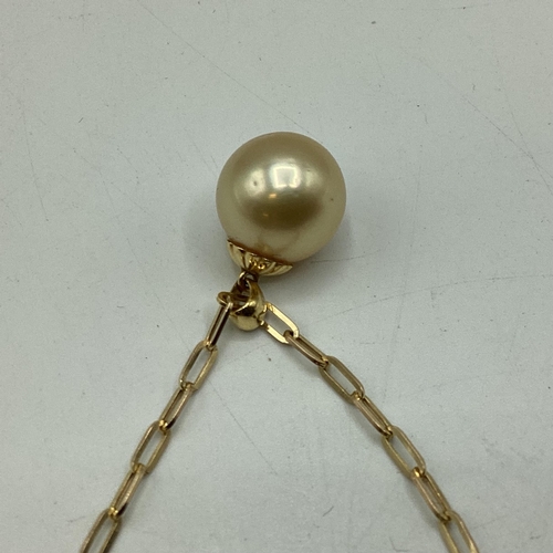 10 - A single golden pearl pendant on 18ct gold bale. Approx 13mm on 9ct gold chain necklace. 46cm. 5.2g.