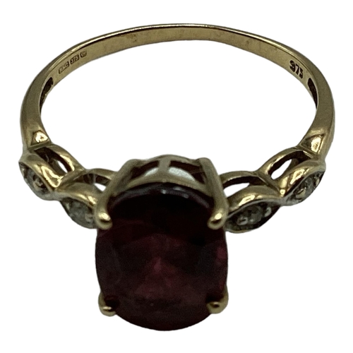 12 - A 9ct gold and Malaya red garnet and diamond ring. Oval free cut garnet in four claw setting with si... 