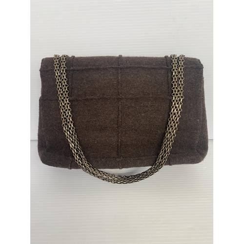 254 - CHANEL, a brown fabric handbag, with original authentication card in envelope, number 5834568, and a... 