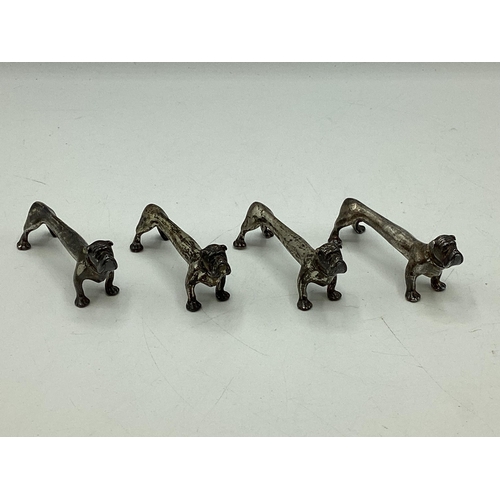 78 - A set of four sterling silver knife rests modelled as stylised hounds. Nat Leslie Ltd, London 1997. ... 