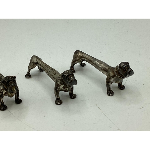 78 - A set of four sterling silver knife rests modelled as stylised hounds. Nat Leslie Ltd, London 1997. ... 