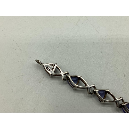 8 - A 9ct white gold and tanzanite set bracelet. Set with sixteen trillion cut tanzanites. Approx 19cm. ... 