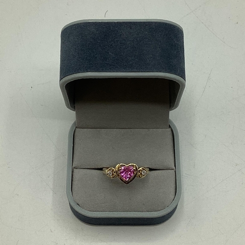 97 - A 10ct gold pink sapphire and diamond ring. Central heart cut sapphire with illusion set single cut ... 