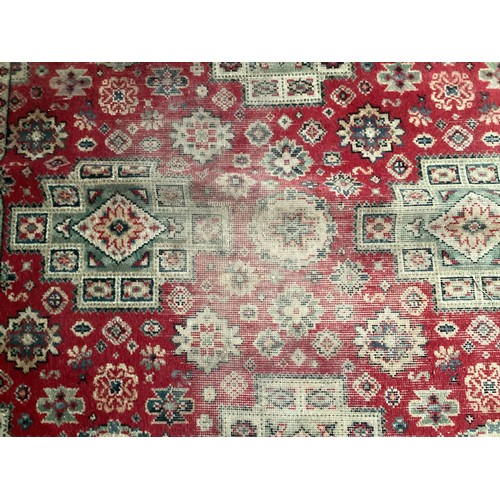 712 - A large Persian style rug with red ground, and all over stylized pattern, Condition:  areas of wear ... 