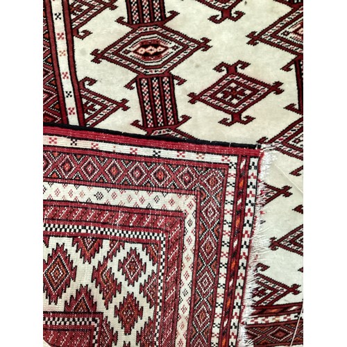 713 - Two Persian style rugs, one with cream and red all over stylized design with some stains, 187cm x 13... 