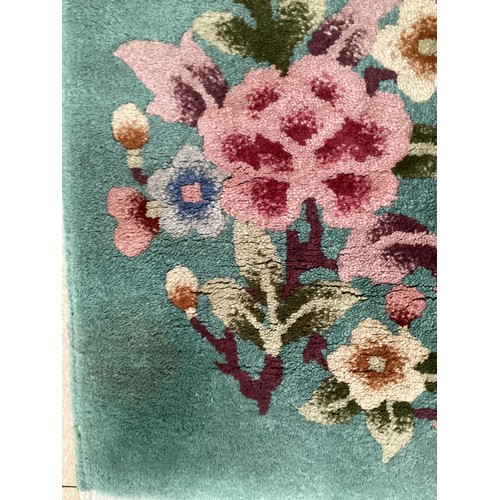 708 - A Chinese wash rug with green ground and floral patterns, 92 x 185cm