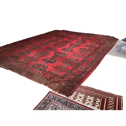 710 - A very large red ground rug with green floral stylized pattern and borders, some all over wear and s... 