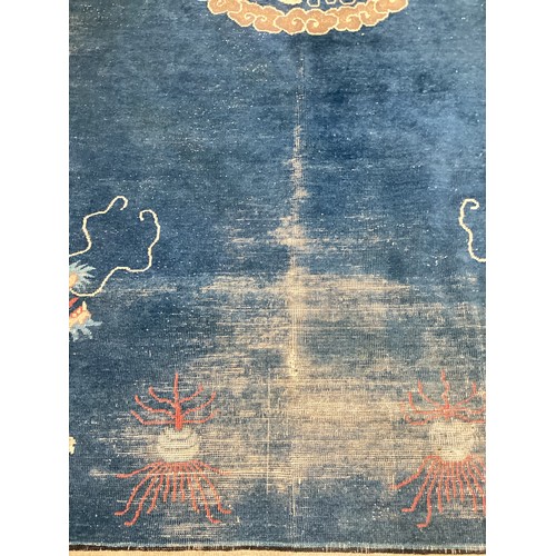 709 - A blue and oatmeal coloured rug, with all over stylized design, dragons illustrated to each corner, ... 