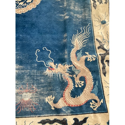 709 - A blue and oatmeal coloured rug, with all over stylized design, dragons illustrated to each corner, ... 