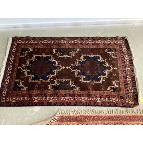 701 - FIVE rugs: A red ground Persian style rug, 158 x 102cm; another with brown ground and  central navy ... 