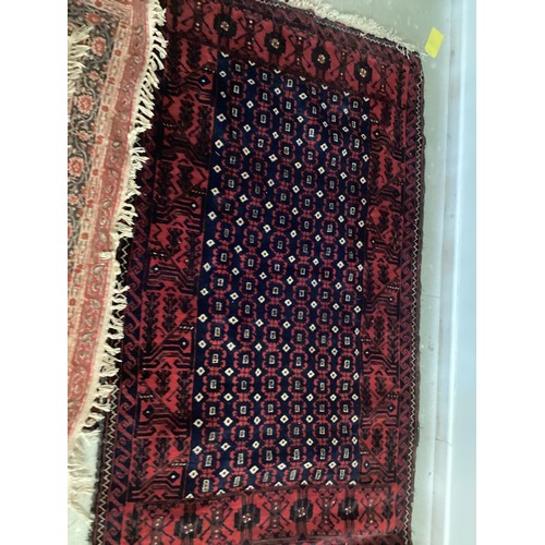 701 - FIVE rugs: A red ground Persian style rug, 158 x 102cm; another with brown ground and  central navy ... 