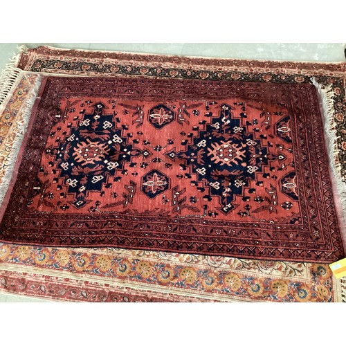 701 - FIVE rugs: A red ground Persian style rug, 158 x 102cm; another with brown ground and  central navy ... 