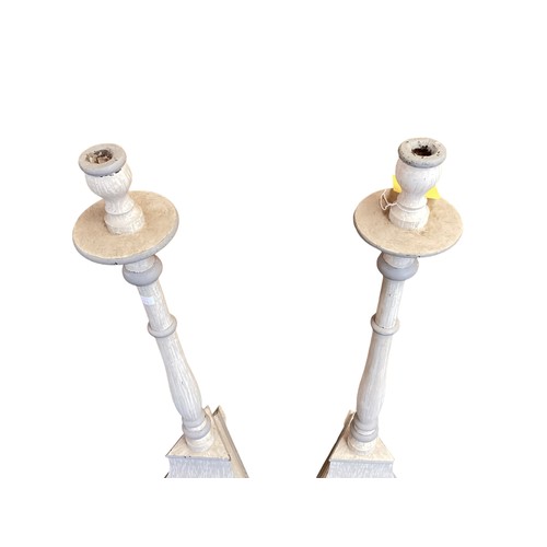 375 - A pair of grey painted wooden floor standing candlesticks. 92cm