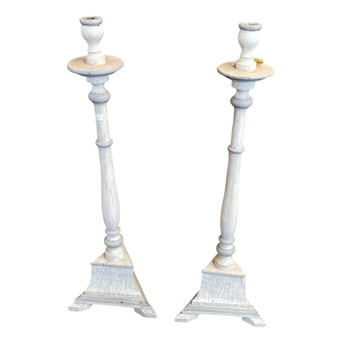 375 - A pair of grey painted wooden floor standing candlesticks. 92cm