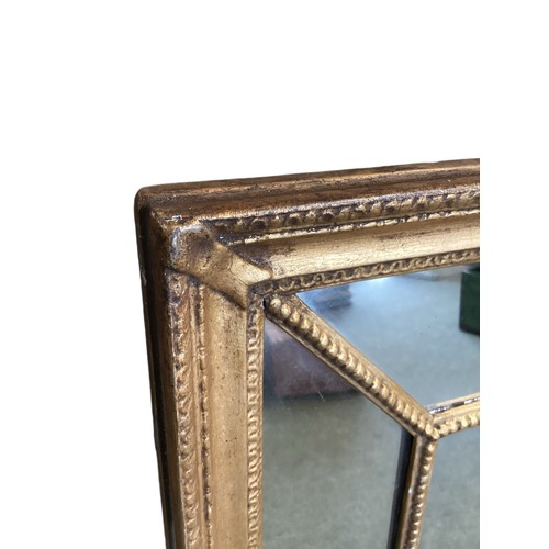 668 - A late Georgian gilt framed rectangular wall mirror with ribbon and bead ornament and mirrored borde... 