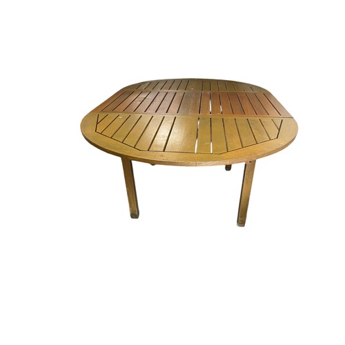 669 - A circular teak extending table with 4 chairs, (2 + 2 carvers), extra leaf for table is integral and... 