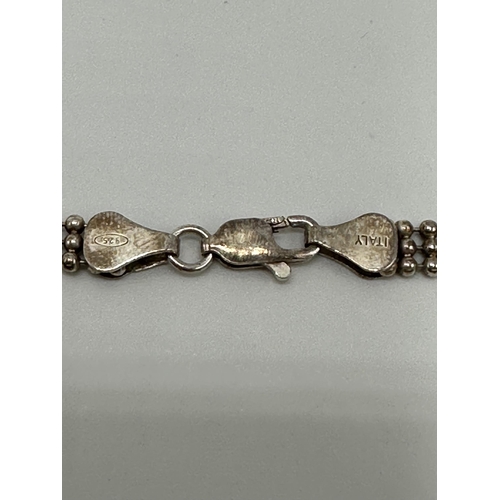 6 - A 9ct gold flat gate link bracelet with 9ct gold heart locket. 25.80g.