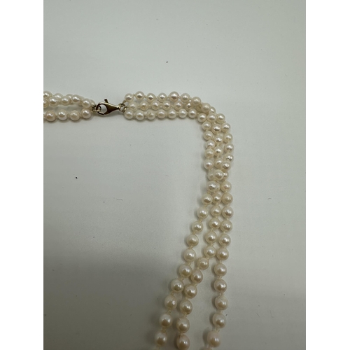 11 - A triple strand of uniform cultured pearls on a 9ct gold clasp. Approx 51cm.