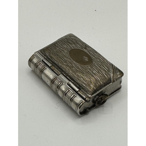 28 - A sterling silver hip shaped cigarette case together with a white metal sovereign holder and vesta i... 