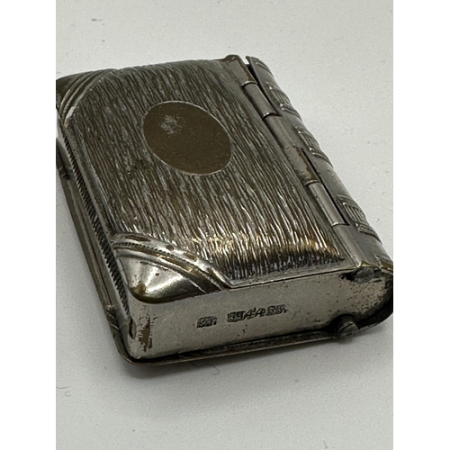 28 - A sterling silver hip shaped cigarette case together with a white metal sovereign holder and vesta i... 