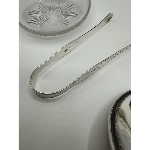 67 - A collection of sterling silver items to include sugar tongs flatware and silver topped glass items.... 