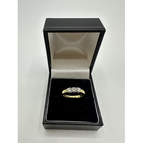 80 - An 18ct gold three stone diamond ring. size N. 3.9g.