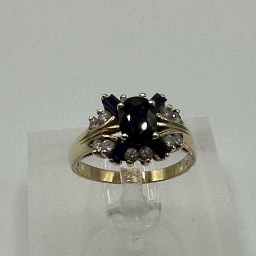 81 - A 14ct gold diamond and sapphire ring. Central oval free cut sapphire with four baguette cut sapphir... 