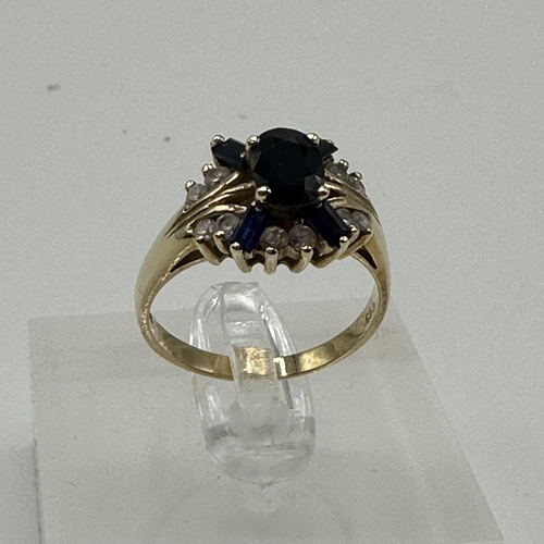 81 - A 14ct gold diamond and sapphire ring. Central oval free cut sapphire with four baguette cut sapphir... 