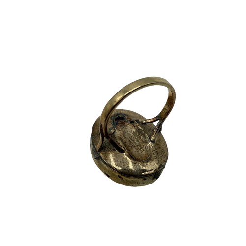 135 - An unmarked yellow metal cameo ring together with an Etruscan style yellow metal brooch.