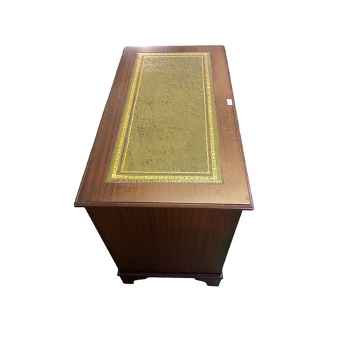 612 - Small mahogany finished kneehole writing desk of 8 drawers and cupboard beneath green tooled leather... 