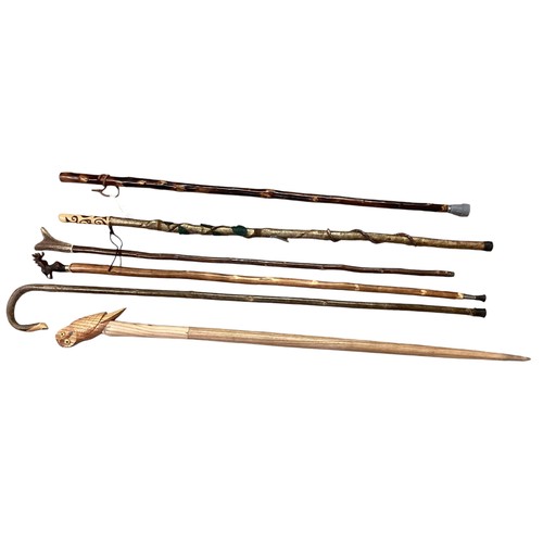 344 - A collection of walking sticks to include shepherd's crook, pilgrimage  sticks and a country thumb s... 