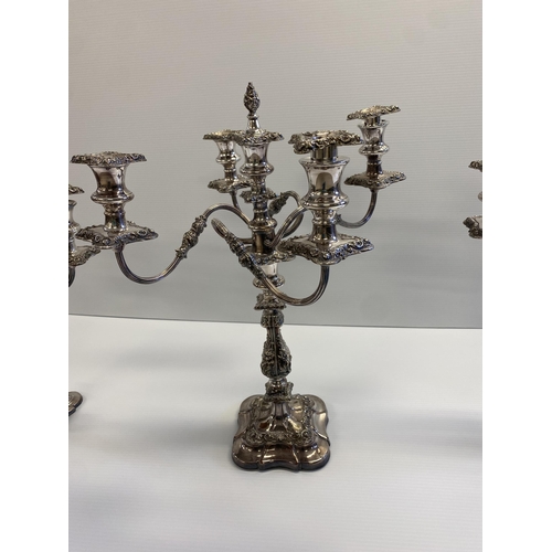 76 - Set of three silver plated table candelabra, central four branch with central holder with finial tog... 