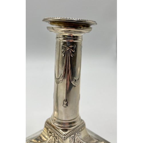 37 - A pair of sterling silver weighted candlesticks, swag and bow design on square bases. Thomas Bradbur... 