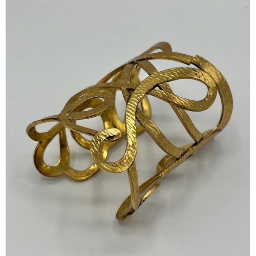 3 - A gilt metal Vintage cuff bracelet by Yves Saint Laurent. Provenance: Formerly the property of a Cou... 