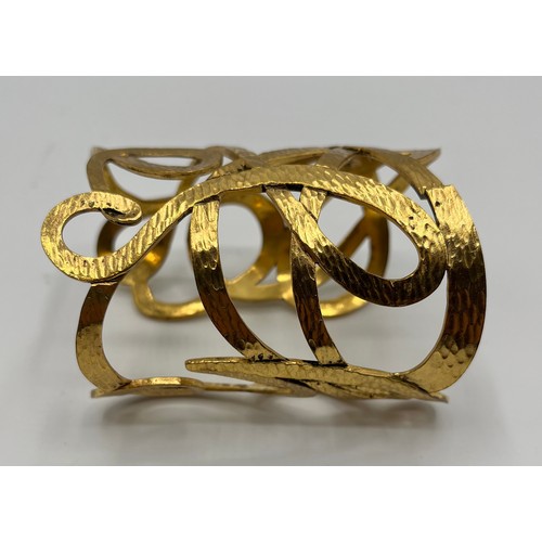 3 - A gilt metal Vintage cuff bracelet by Yves Saint Laurent. Provenance: Formerly the property of a Cou... 