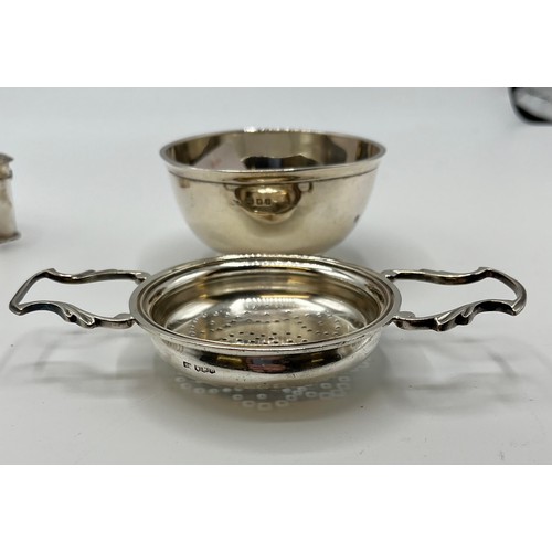 20 - A collection of sterling silver items to include an art Deco style toast rack, tea strainer salts et... 