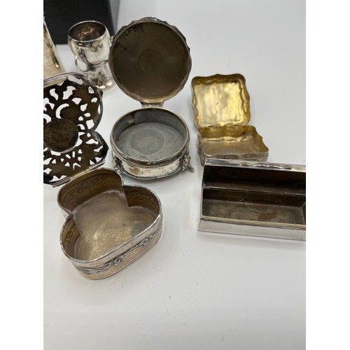 10 - A collection of sterling silver bijouterie items to include pierced boxes, a small go to bed a troph... 