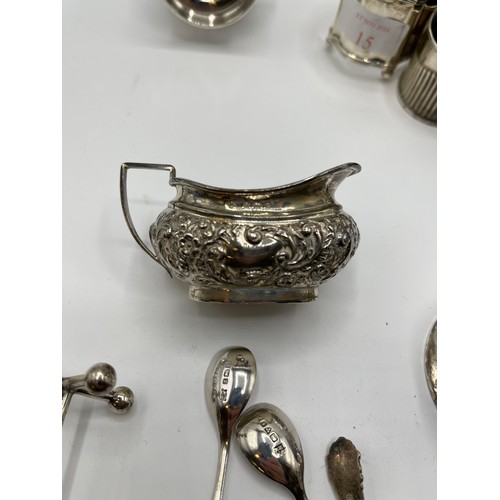 15 - A collection of sterling silver items to include a Georgian sugar sifter, toast rack, pepperettes et... 