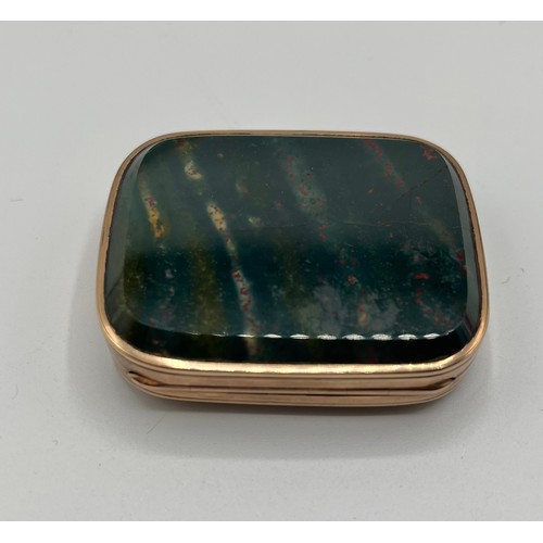 81 - An unmarked yellow metal snuff set with hardstone panels together with a similar oval unmarked white... 