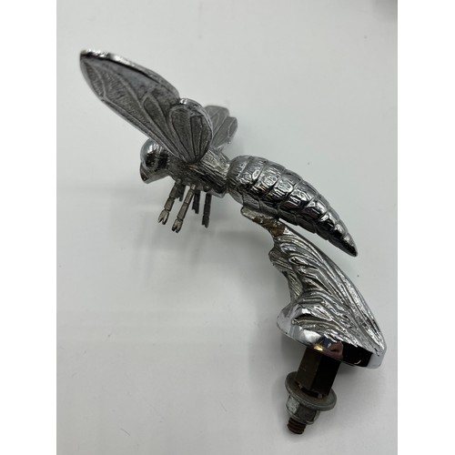 95 - A white metal car mascot in the form of a Hornet together with a white metal duck head novelty bottl... 