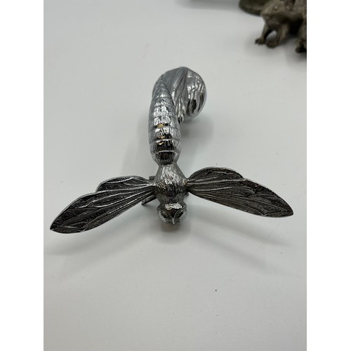 95 - A white metal car mascot in the form of a Hornet together with a white metal duck head novelty bottl... 