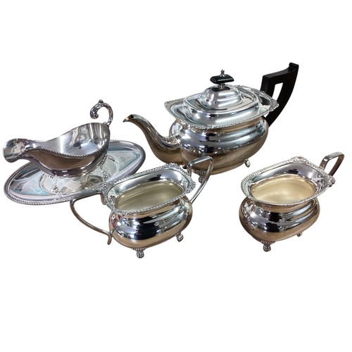 101 - A collection of silver plated wares to include a three piece tea set , Taza, sauce boat etc.