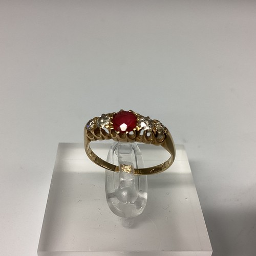 24 - An 18ct gold ruby and diamond ring. central round free cut ruby with old cut diamond accents. Size M... 