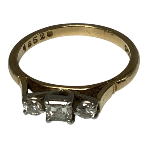 25 - An 18ct gold and platinum three stone diamond ring. Central square cut diamond with brilliant cut ac... 