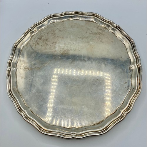 115 - A large sterling silver circular tray  raised on four shell feet. Engraved to underside 'To Major RH... 