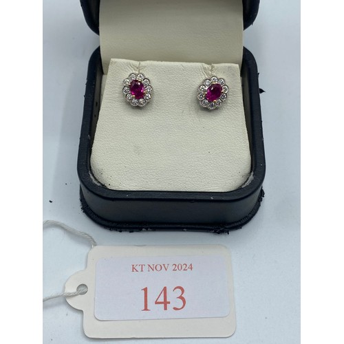 143 - A pair of 18ct yellow and white gold ruby and diamond ear studs. 3.6g.