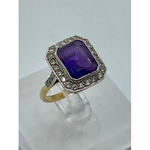 146 - An 18ct yellow and white gold amethyst and diamond dress ring. Emerald cut amethyst with a surround ... 