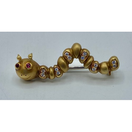 137 - An 18 ct gold and diamond caterpillar broach with ruby set eyes 32 mm, 6.6 g