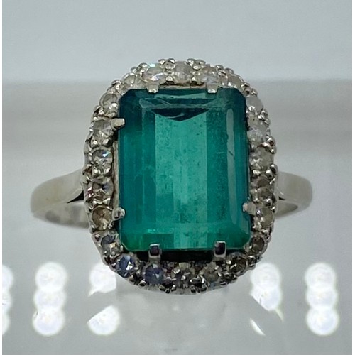 141 - An 18 ct white gold Emerald and Diamond dress ring central step cut Emerald, 13 x 9 mm approx with a... 